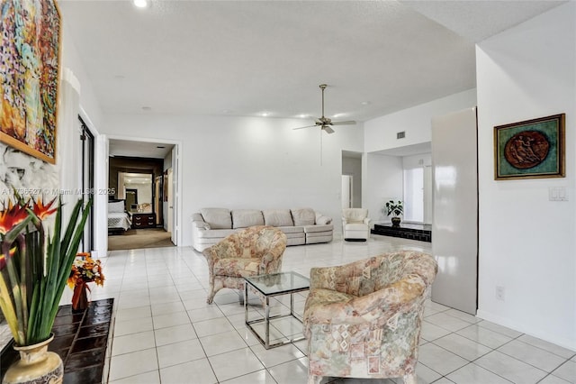 living room with light tile patterned flooring, visible vents, and a ceiling fan