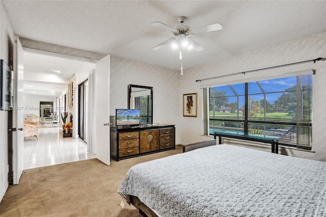 bedroom featuring carpet floors, a ceiling fan, and a textured ceiling