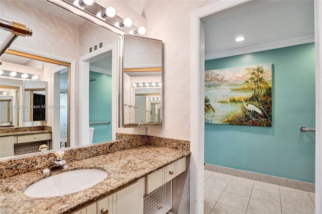 bathroom with vanity, baseboards, crown molding, and tile patterned floors