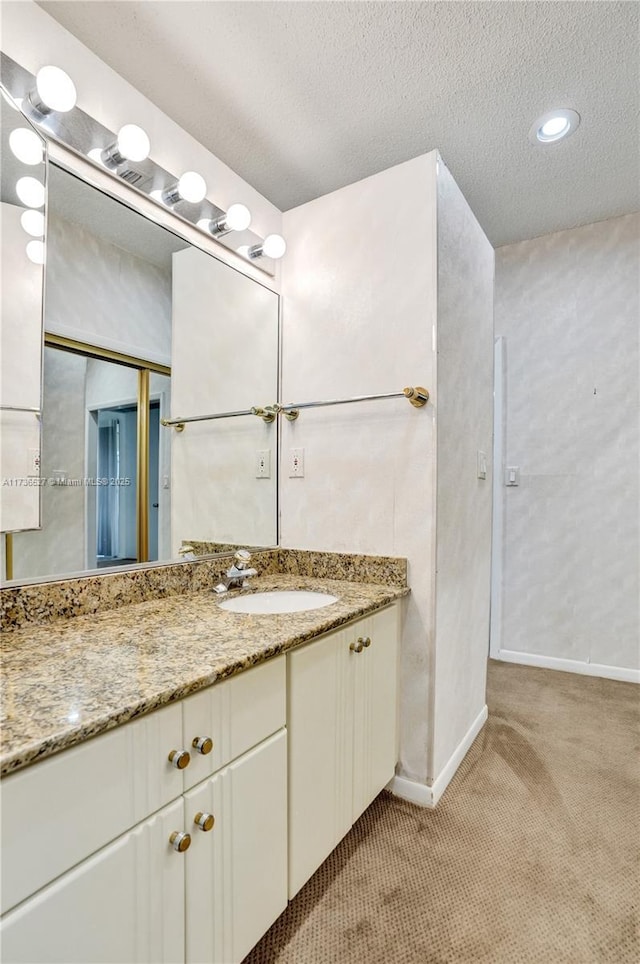 bathroom featuring a textured ceiling, vanity, and baseboards