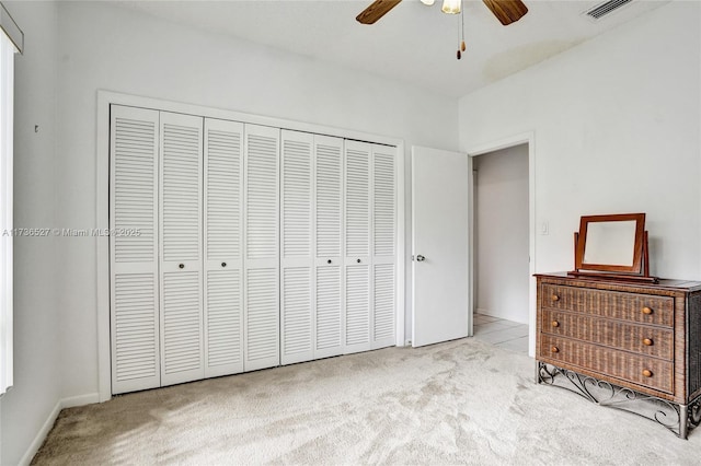 unfurnished bedroom featuring a closet, carpet flooring, ceiling fan, and visible vents