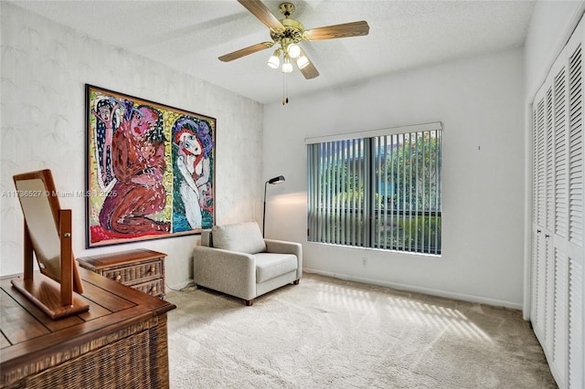 sitting room featuring a ceiling fan, carpet flooring, a textured ceiling, and baseboards