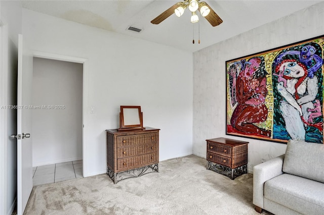 living area featuring tile patterned flooring, visible vents, ceiling fan, and carpet flooring