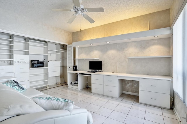 office space featuring a ceiling fan, light tile patterned flooring, a textured ceiling, and built in study area