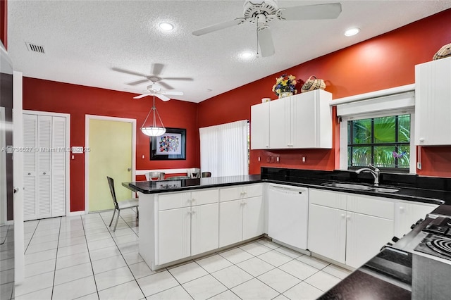 kitchen with a peninsula, a sink, white cabinetry, dishwasher, and dark countertops