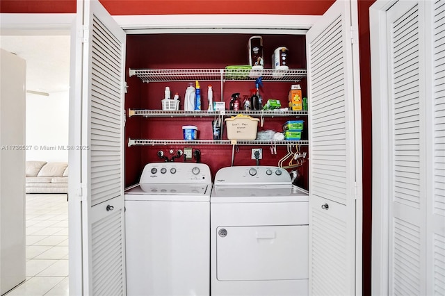 washroom featuring laundry area, light tile patterned flooring, and washing machine and clothes dryer