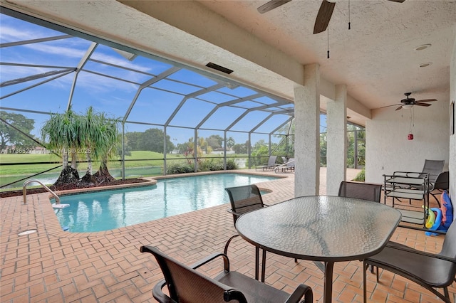 outdoor pool featuring a patio area, glass enclosure, a ceiling fan, and outdoor dining space