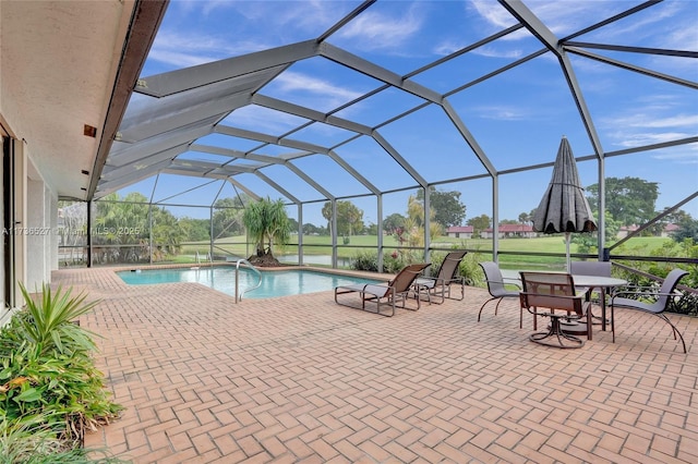 outdoor pool featuring glass enclosure and a patio