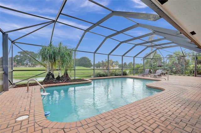 pool with a patio area, glass enclosure, and a yard