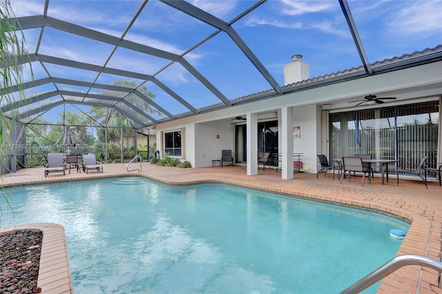 pool featuring a patio area, ceiling fan, and glass enclosure