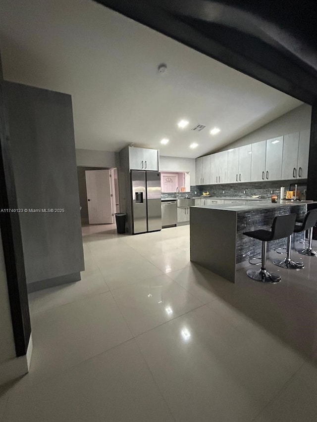 15281 SW 153rd St, Miami, FL 33187 - kitchen featuring stainless steel appliances, backsplash, white cabinets, light tile patterned flooring, and a peninsula