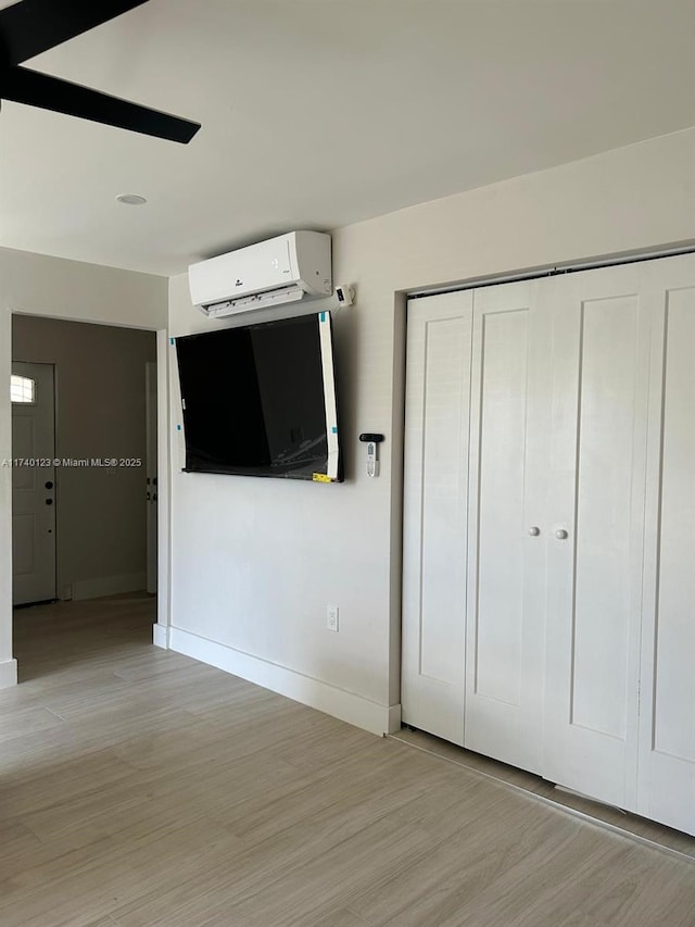 15281 SW 153rd St, Miami, FL 33187 - unfurnished bedroom featuring an AC wall unit, a closet, light wood-type flooring, and baseboards