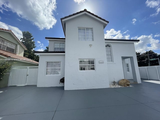 12676 NW 7th Ln, Miami, FL 33182 - back of house with stucco siding, a patio area, and a gate