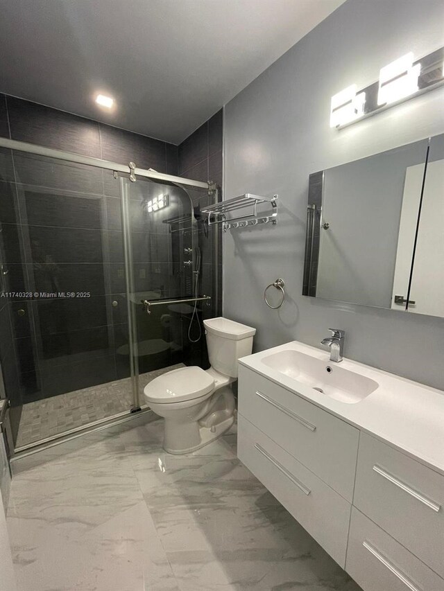 bathroom featuring vanity, toilet, and walk in shower