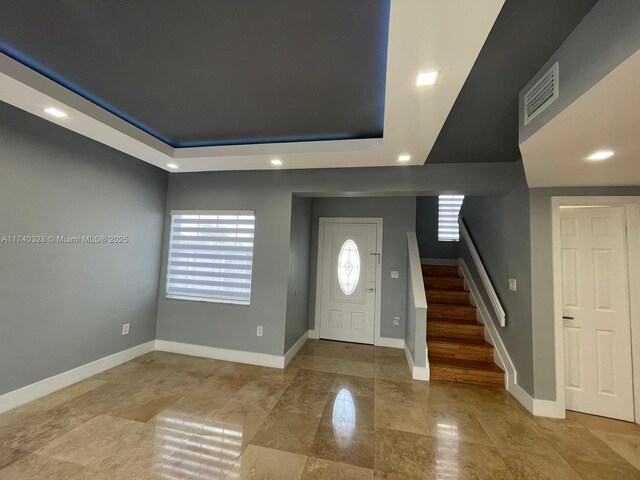 foyer with a wealth of natural light and a raised ceiling