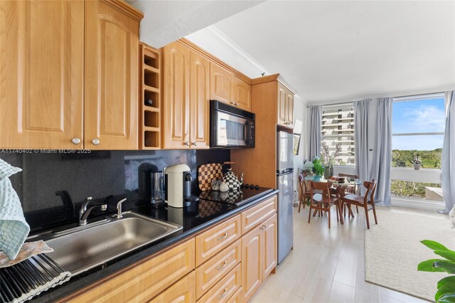 kitchen with light brown cabinetry, sink, tasteful backsplash, crown molding, and black appliances