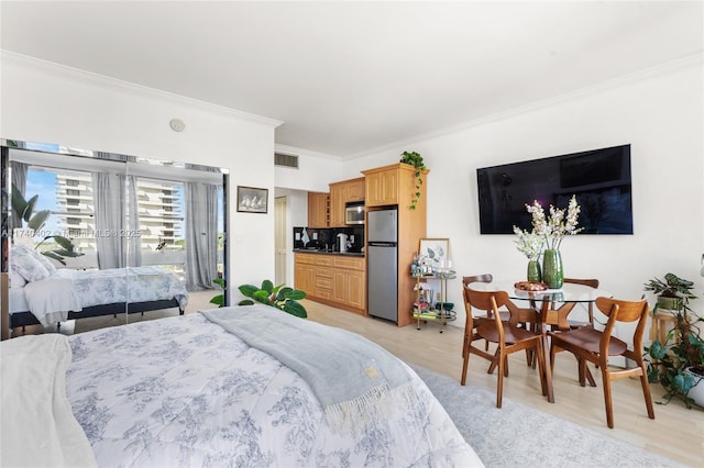 bedroom featuring crown molding, access to outside, light hardwood / wood-style floors, and stainless steel refrigerator