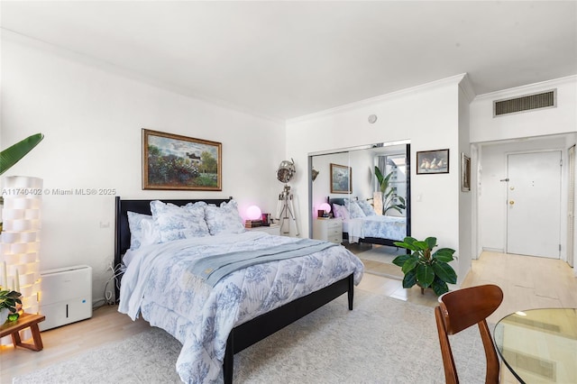 bedroom featuring crown molding and light hardwood / wood-style floors