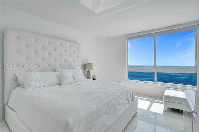 bedroom featuring light tile patterned floors and a water view