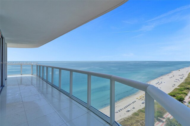 balcony with a beach view and a water view