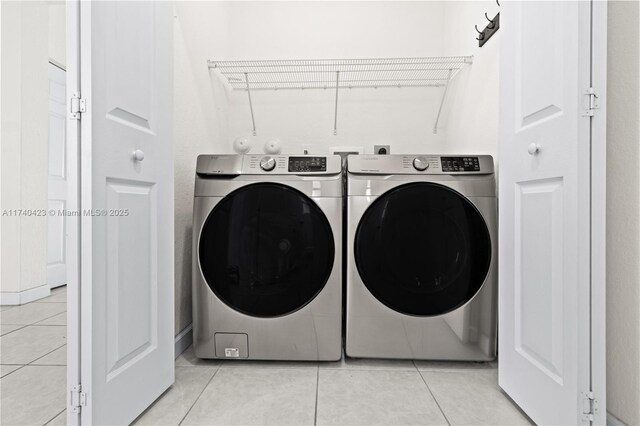 laundry room with light tile patterned flooring and washer and dryer