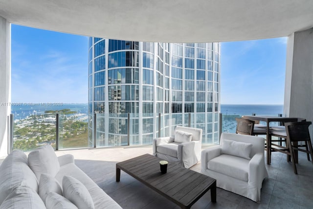 living room featuring tile patterned flooring, floor to ceiling windows, and a water view