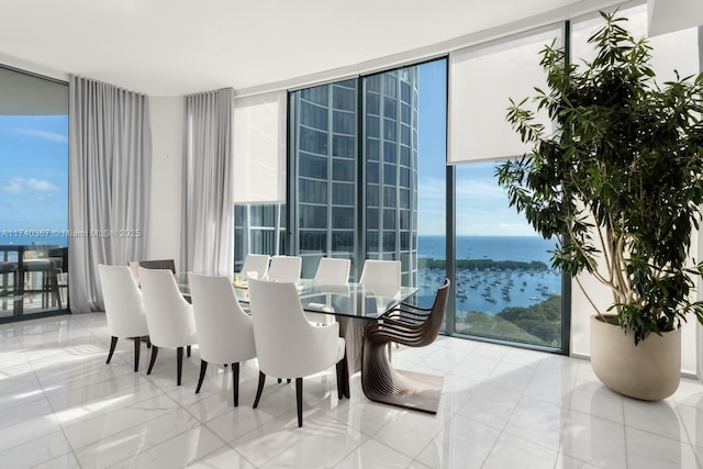 dining area with a water view and a wall of windows