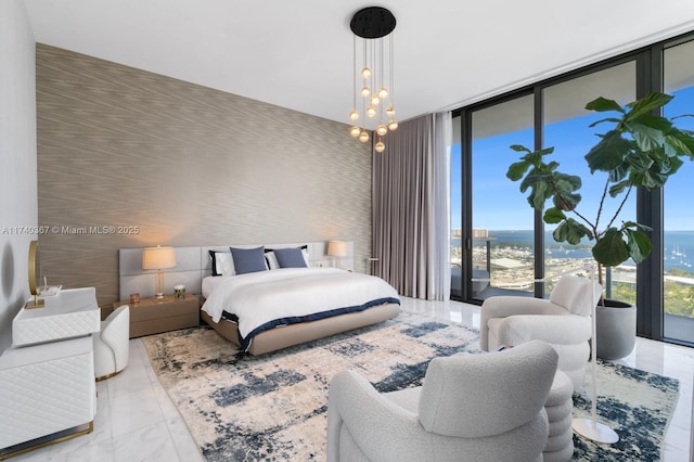 bedroom featuring a water view, floor to ceiling windows, a chandelier, and access to outside