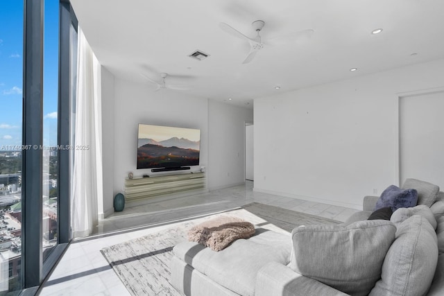 living room featuring floor to ceiling windows and ceiling fan