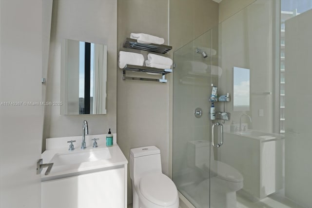 bathroom featuring vanity, toilet, and a shower with shower door