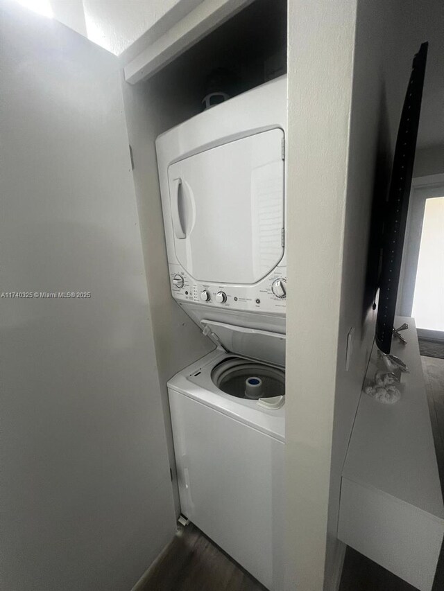 222 SW 8th St, Dania Beach, FL 33004 - laundry area with stacked washing maching and dryer and dark hardwood / wood-style flooring
