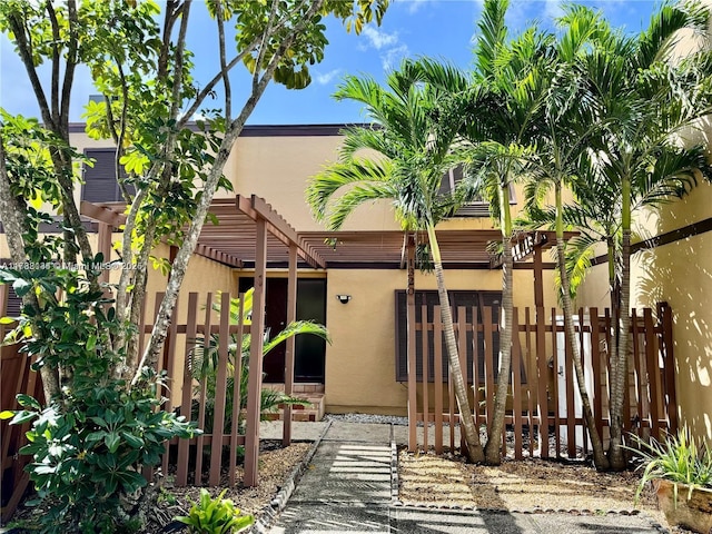 rear view of property featuring a pergola