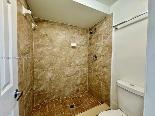 bathroom with toilet and a tile shower