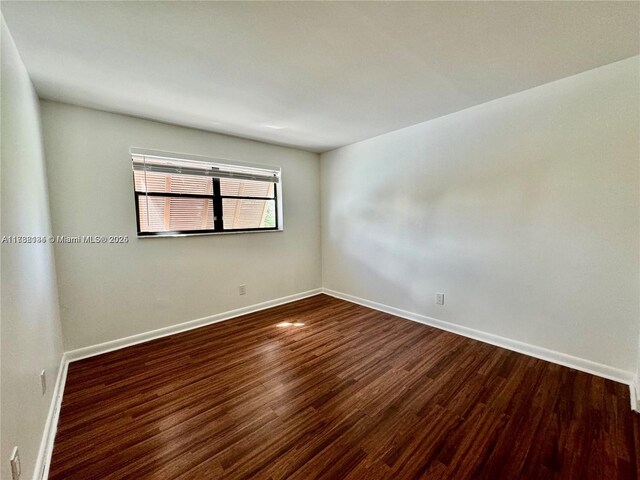 empty room with dark hardwood / wood-style flooring