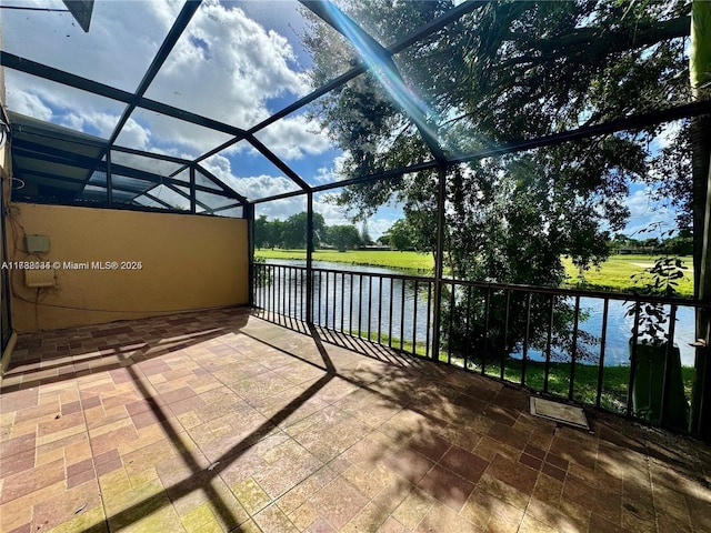 view of patio / terrace featuring a water view and a lanai