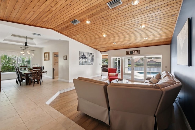 living room featuring vaulted ceiling, light tile patterned floors, a tray ceiling, wooden ceiling, and french doors