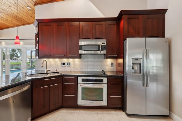 kitchen featuring lofted ceiling, appliances with stainless steel finishes, sink, and decorative backsplash