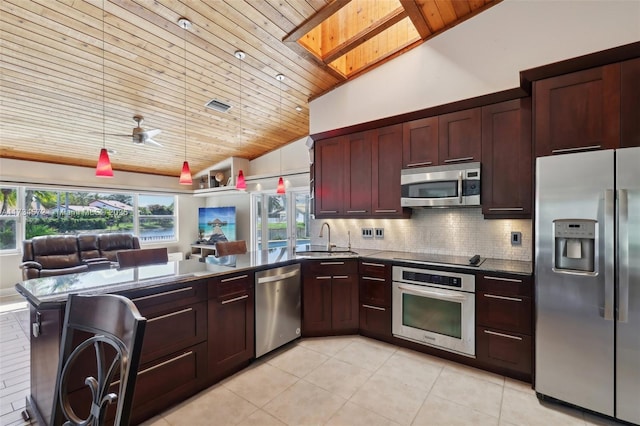 kitchen with appliances with stainless steel finishes, sink, decorative backsplash, hanging light fixtures, and kitchen peninsula