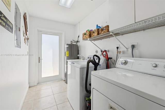 washroom featuring light tile patterned flooring, washer and dryer, and electric water heater