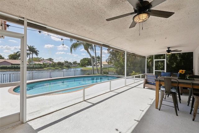 view of swimming pool with a water view and a patio area