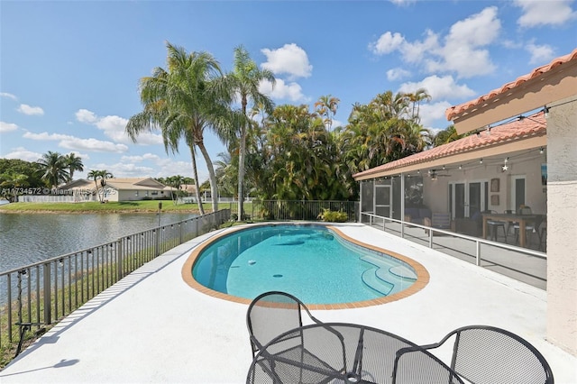 view of swimming pool featuring a patio, a water view, and a sunroom