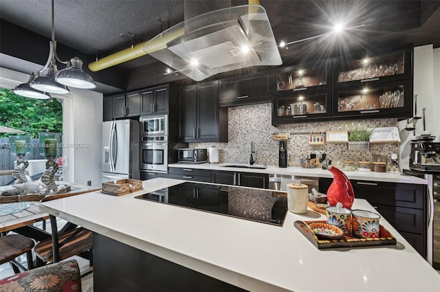 kitchen featuring sink, a breakfast bar, hanging light fixtures, backsplash, and stainless steel appliances