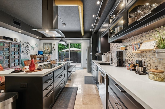 kitchen featuring sink, appliances with stainless steel finishes, a kitchen island with sink, island exhaust hood, and decorative light fixtures