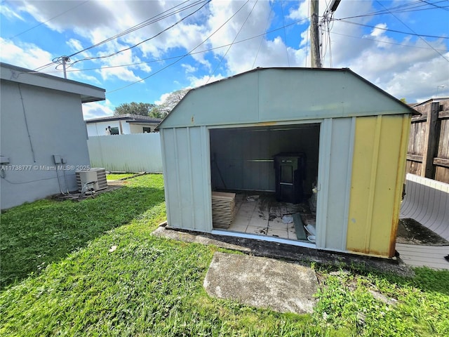 view of outdoor structure with a yard and central AC