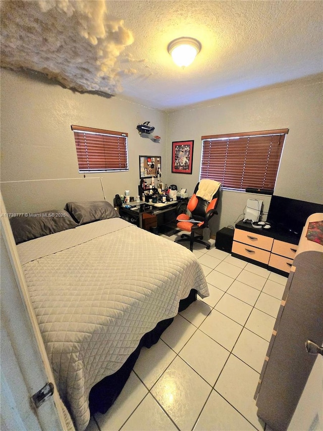 bedroom with tile patterned floors and a textured ceiling