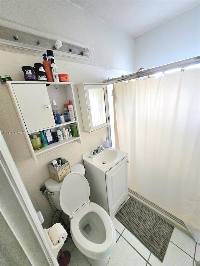 bathroom with tile patterned floors, toilet, curtained shower, and vanity