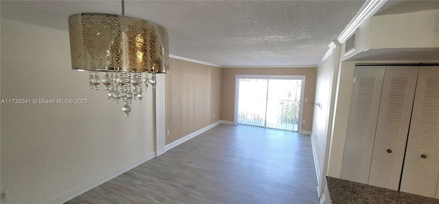 hall featuring hardwood / wood-style floors, crown molding, and a textured ceiling