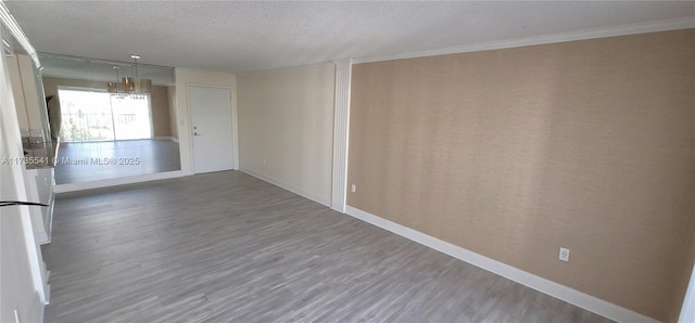 empty room featuring a textured ceiling, crown molding, and dark hardwood / wood-style floors