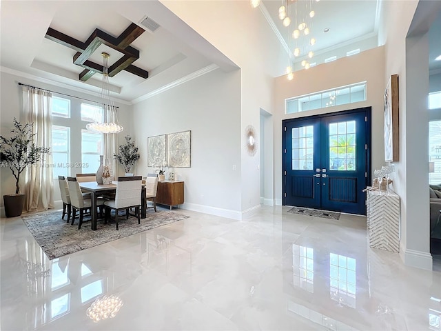 foyer with a high ceiling, coffered ceiling, a notable chandelier, ornamental molding, and french doors