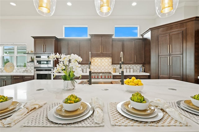 kitchen featuring double oven, decorative light fixtures, and ornamental molding